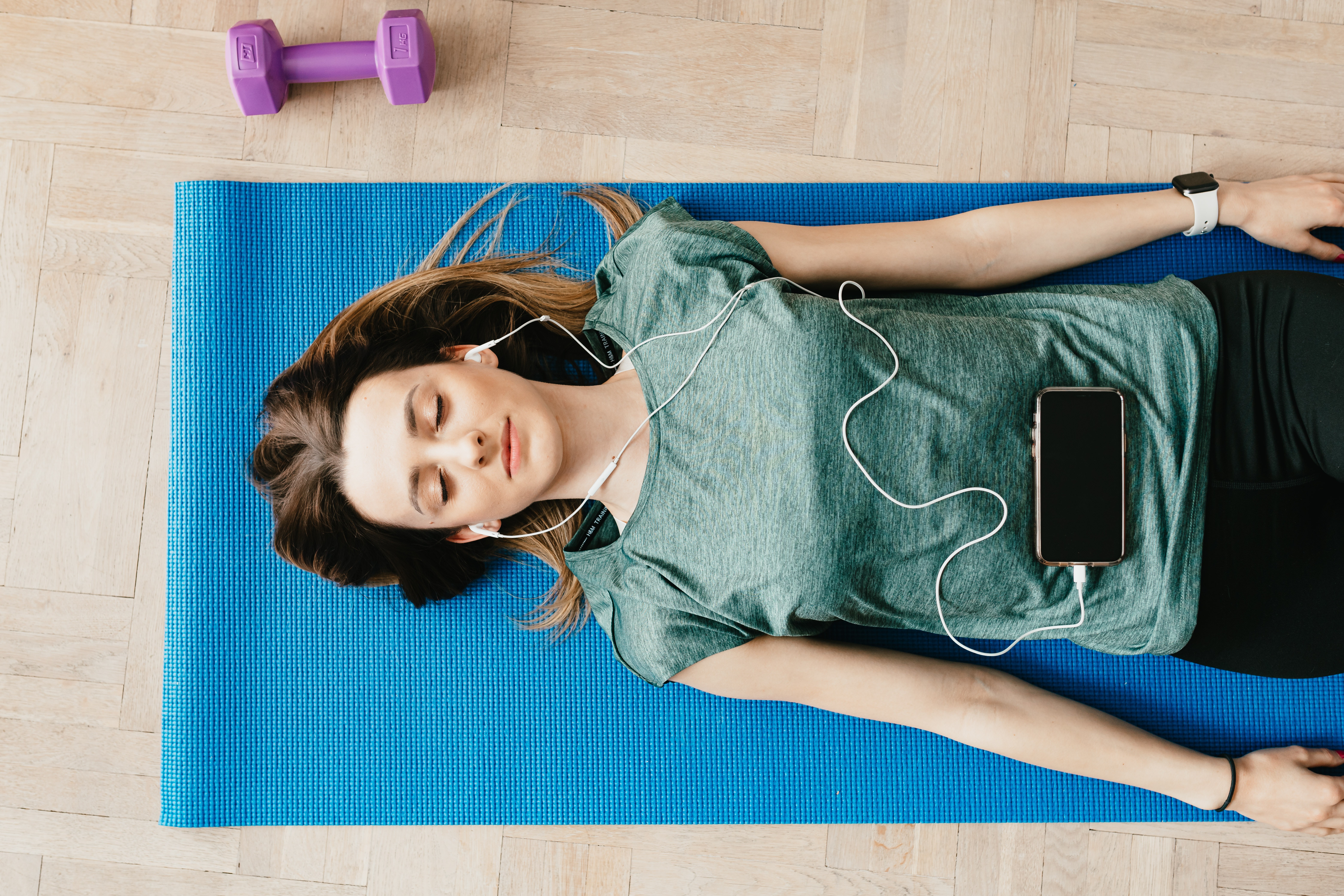 Woman lying down with headphones in.